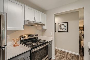 a kitchen with white cabinets and stainless steel appliances